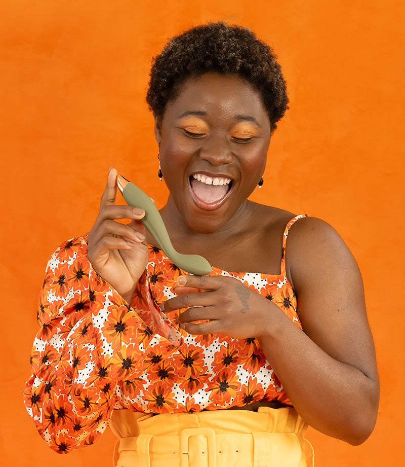 Happy woman holds bestie finger shaped vibrator.