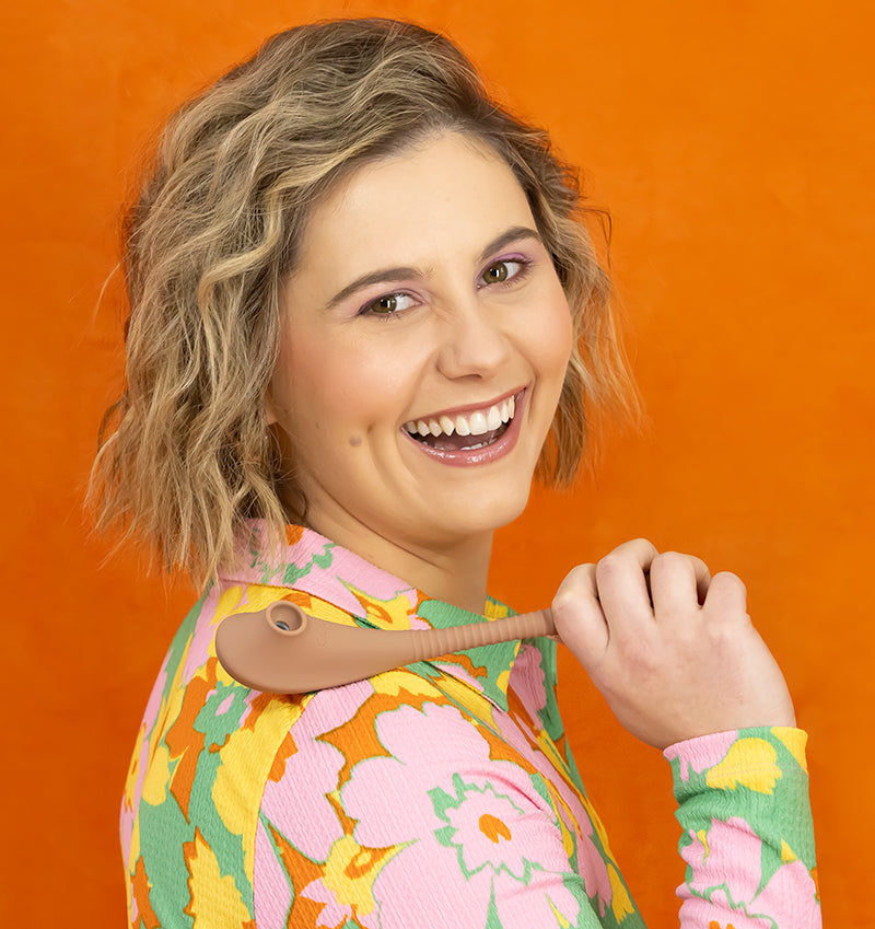 Woman holding a Dos Amigos dual head vibrator while smiling.