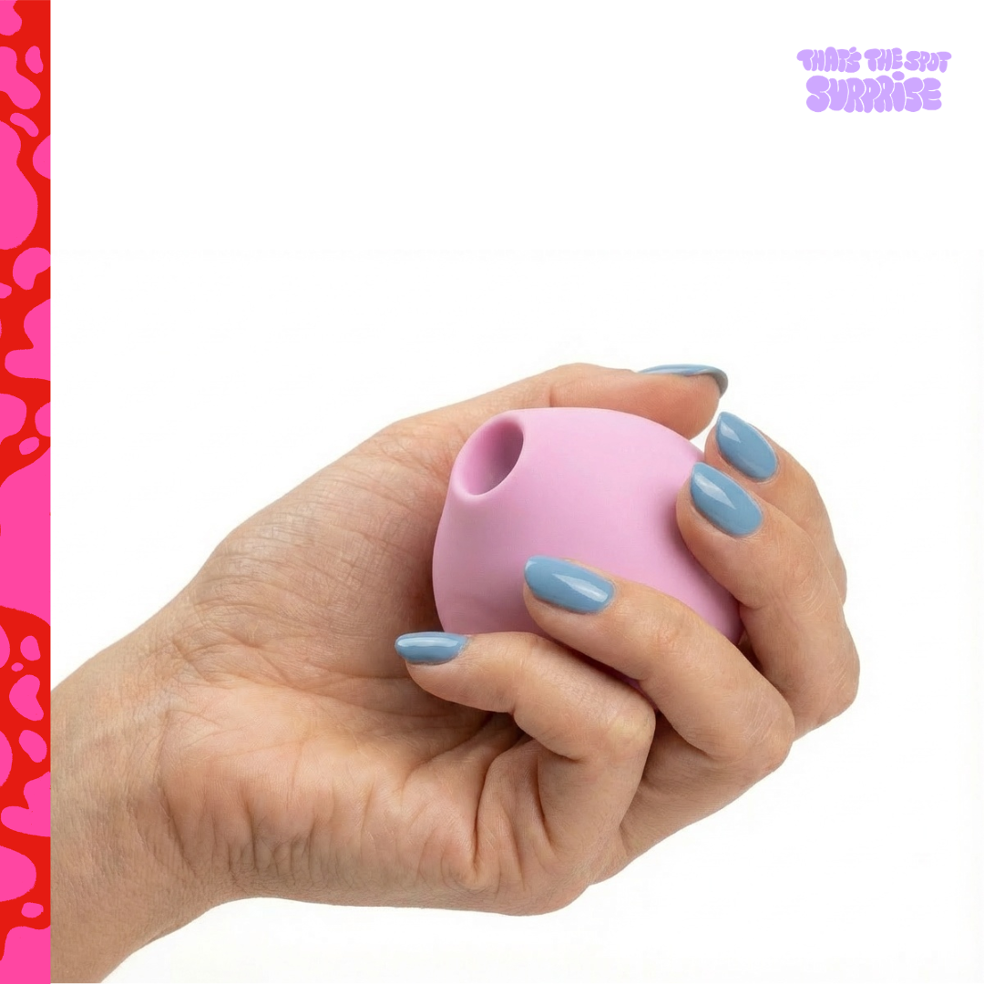 Hand holding a pink round suction vibrator from That's The Spot Surprise blind box.