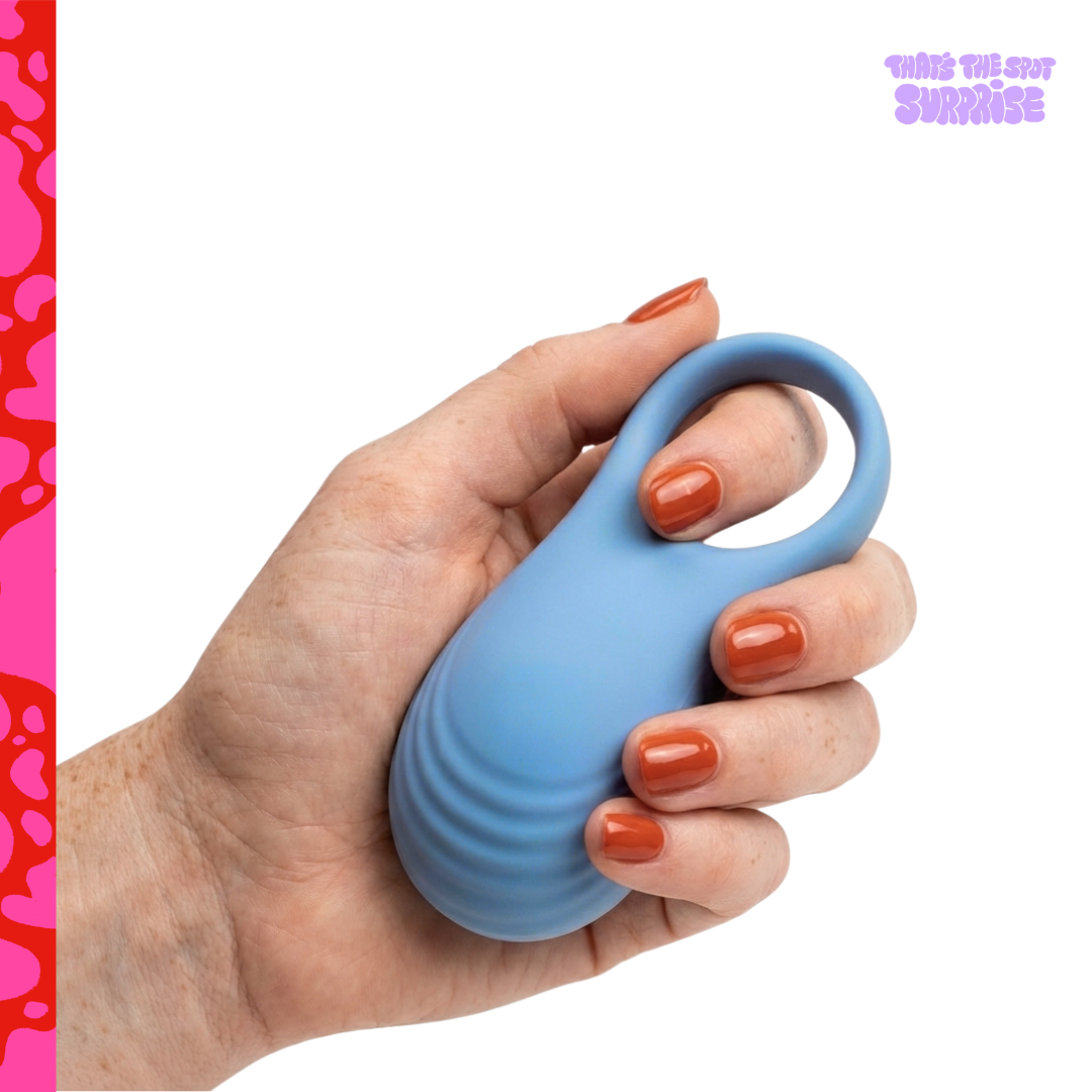 Hand holding a blue vibrating cock ring from That's The Spot Surprise blind box.